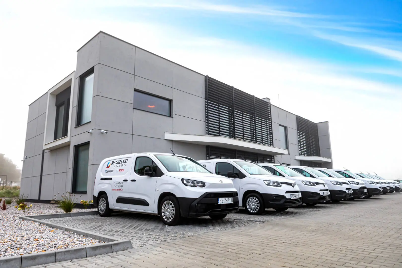 Flota samochodów serwisu Junkers Poznań przed siedzibą Machelski Serwis
